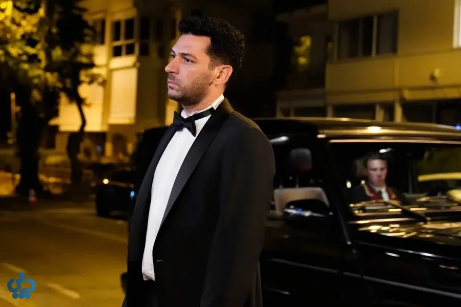 شخصیت مرد سریال گل‌ها و گناهان با لباس رسمی کنار خودرو در شب